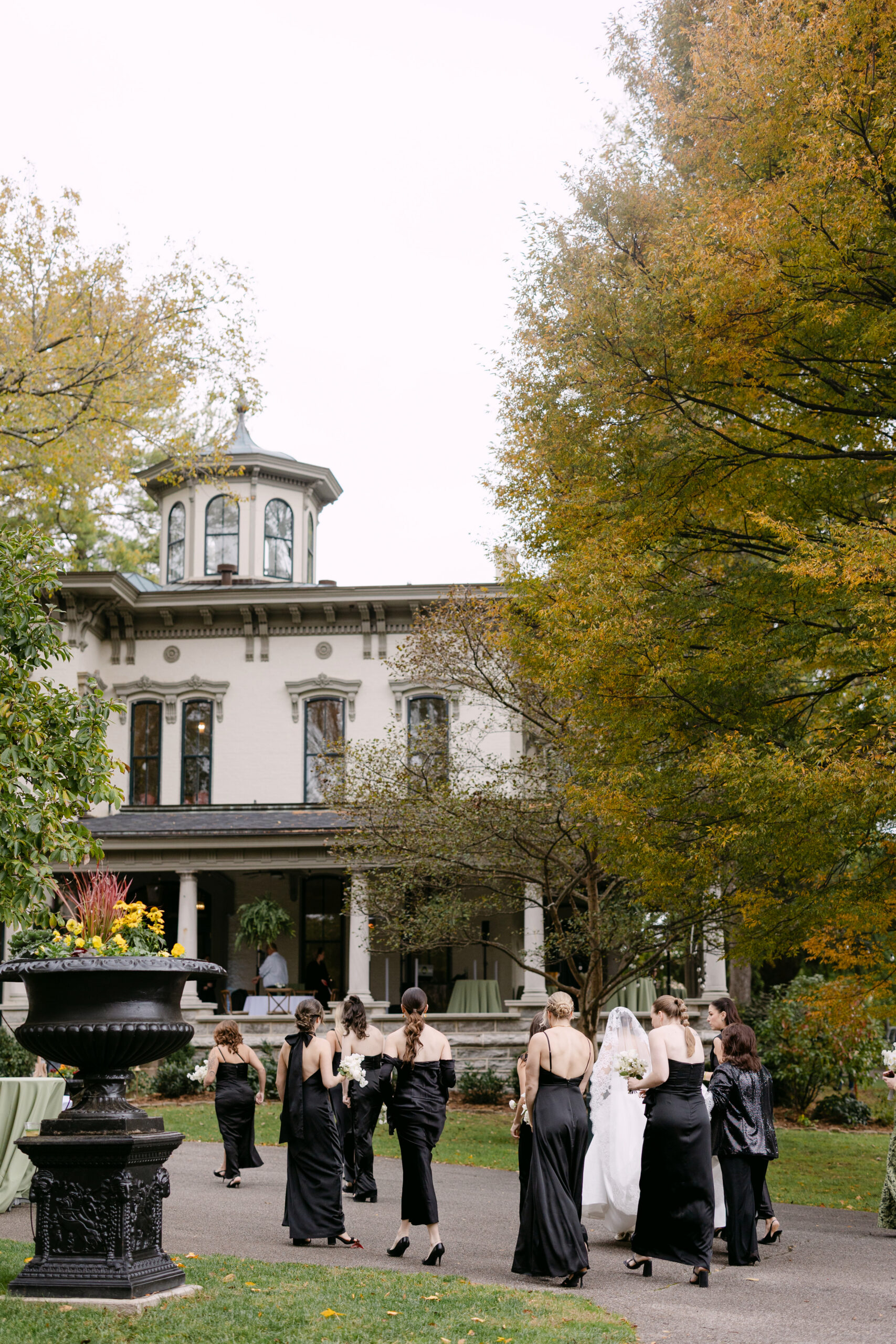 Bridesmaids walking towards Peterson Dumesnil House in Louisville KY