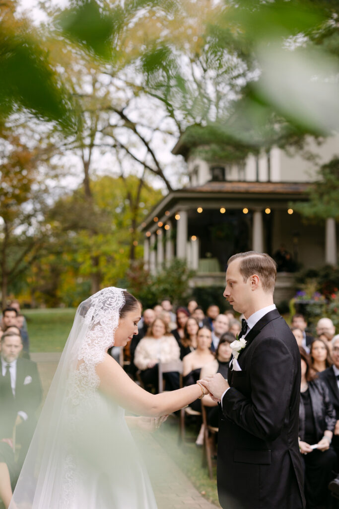 Close-up of couple holding hands during outdoor ceremony at Peterson Dumesnil House in Louisville KY