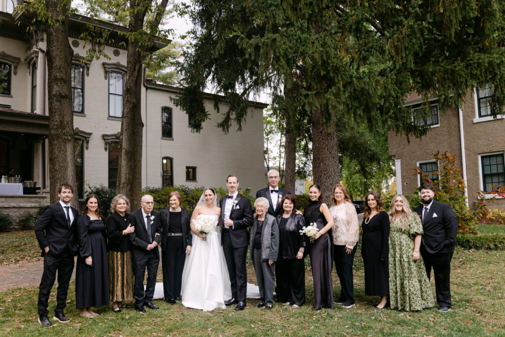 Bride and groom posing with family at Peterson Dumesnil House wedding in Louisville Kentucky