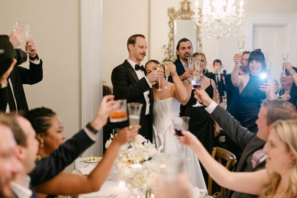 Wedding guests cheering during reception speeches at Peterson Dumesnil House in Louisville