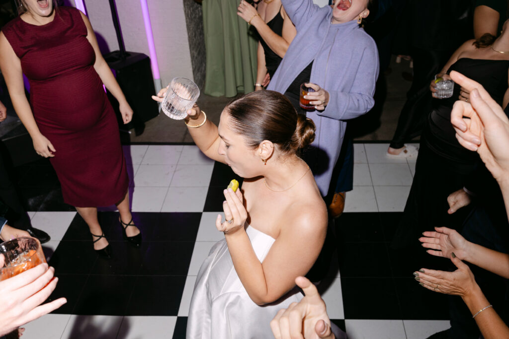 Bride taking tequila shot on dance floor at Peterson Dumesnil House wedding reception