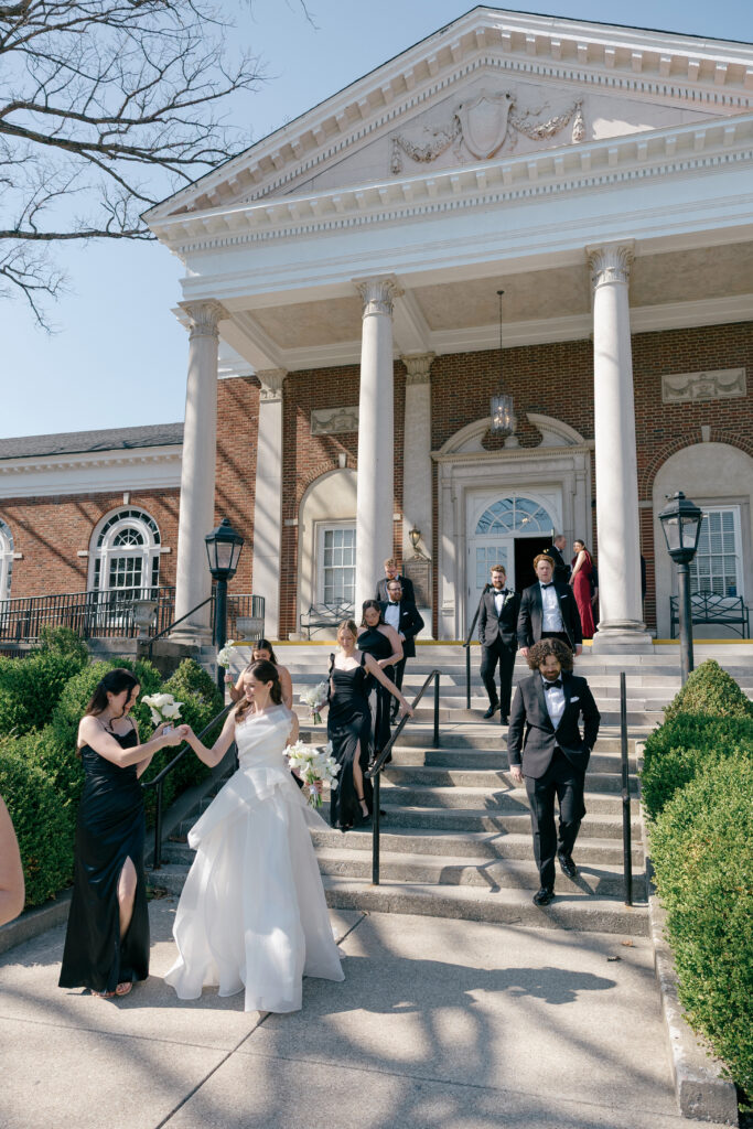 Bridal party portraits walking down the front steps at The Olmsted wedding venue in Louisville, Kentucky